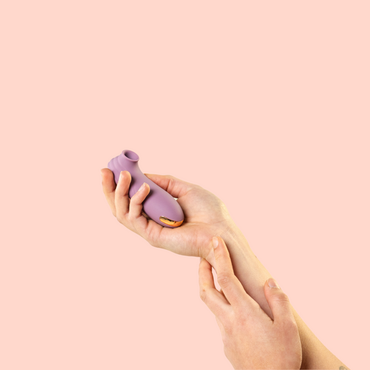holding the purple clit sucker sex toy